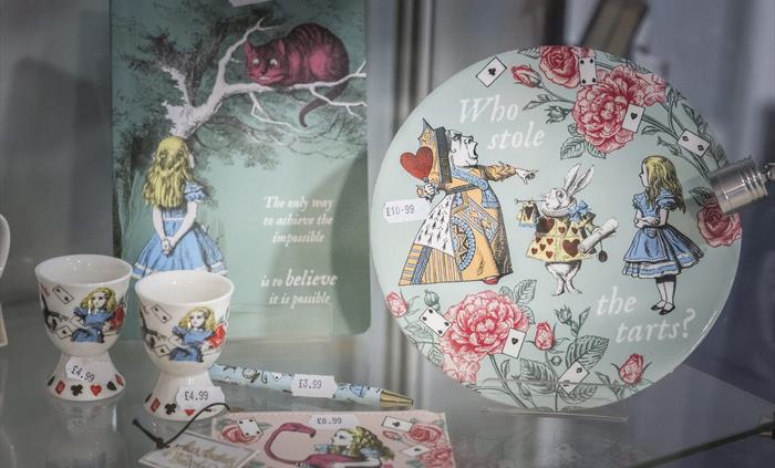 Alice in Wonderland themed souvenirs including plates, egg cups, notebooks and keepsakes inspired by Llandudno’s connection to Alice.